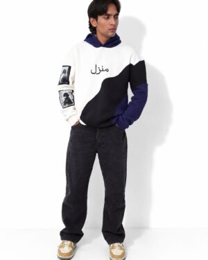 Model in the Manzil navy, white and black colour-block hoodie, standing full length